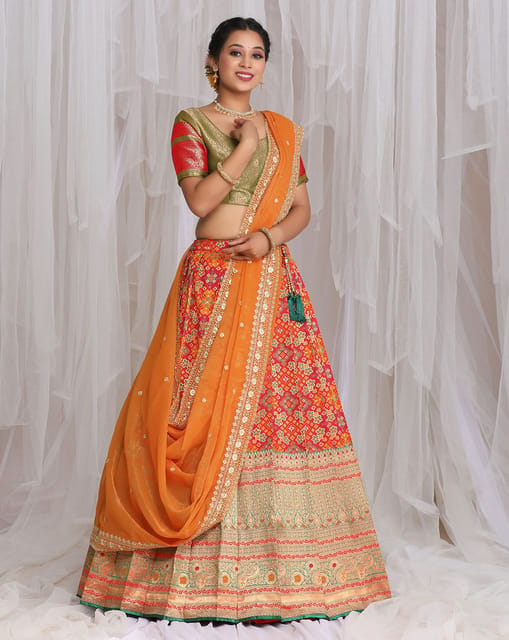 REDDISH ORANGE CLASSIC PRINTED BRIDAL LEHENGA SET WITH MOTIFS PAIRED WITH A  MATCHING DUPATTA AND HAND EMBROIDERED GOLD DETAILS. - Seasons India
