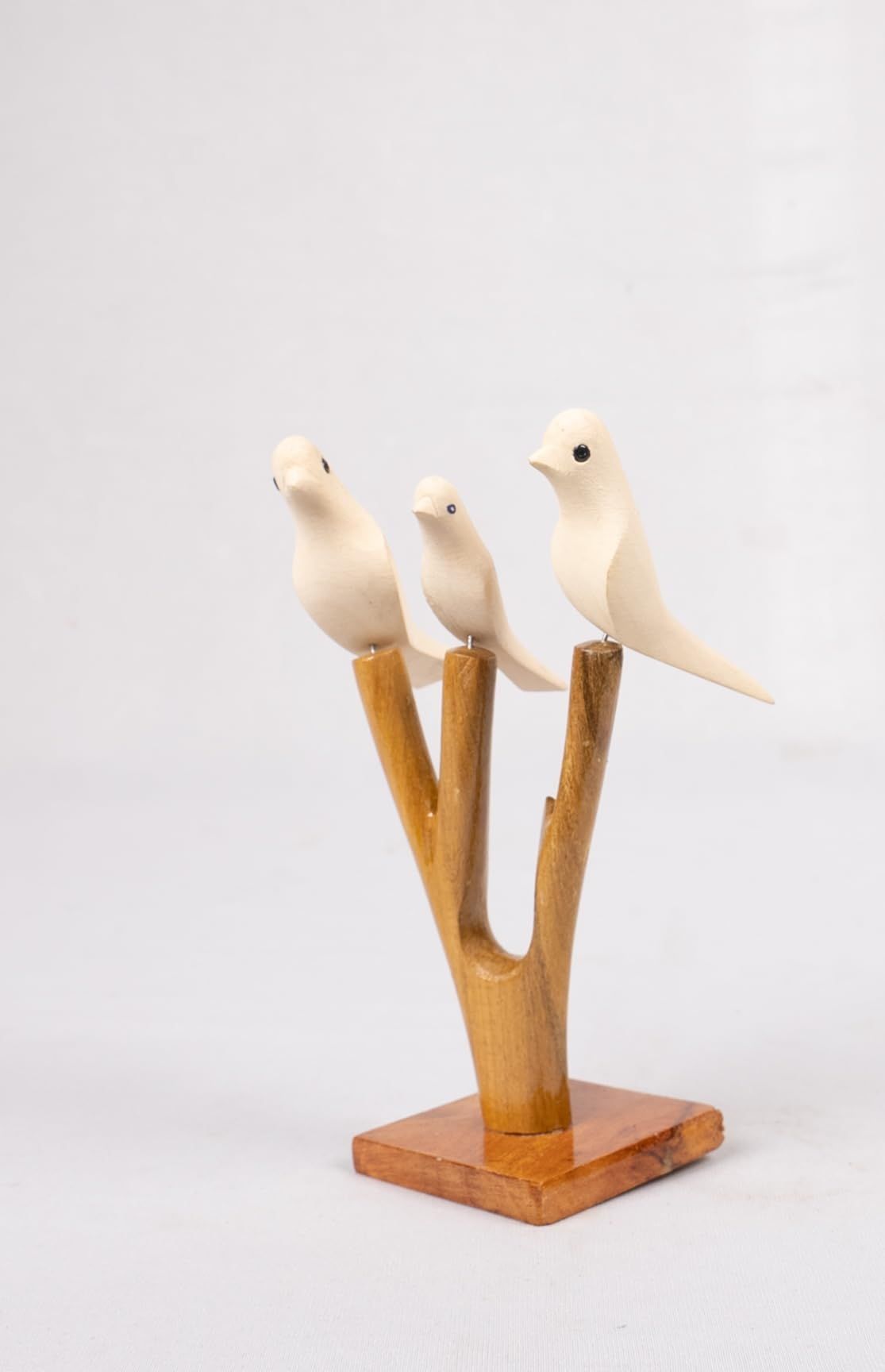 Three White Wooden Birds on a Branch