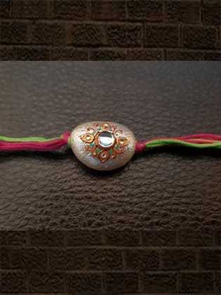 Hand painted white bead rakhi with kundan stone in green and pink thread