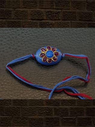 Blue oval bead with red stone flower with same colour thread rakhi