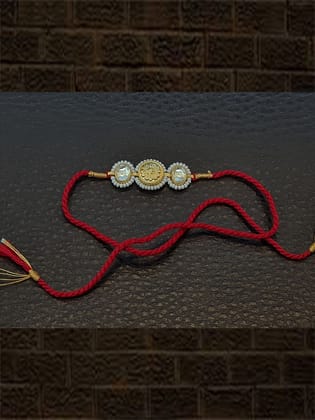 Kundan on sides of antique tukdi pirohi work red thread rakhi