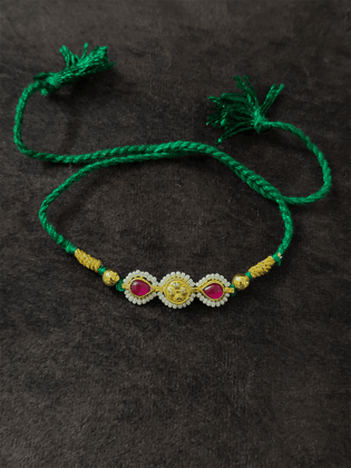 Two ruby leaf stones with pirohi work and antique tukdi rakhi in green thread