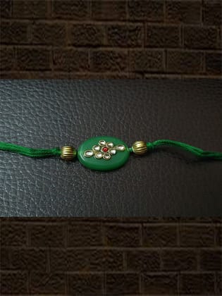 Oval green stone rakhi with kundan and red stone