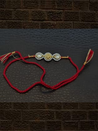 Two kundan's with pirohi work and antique tukdi rakhi in red thread